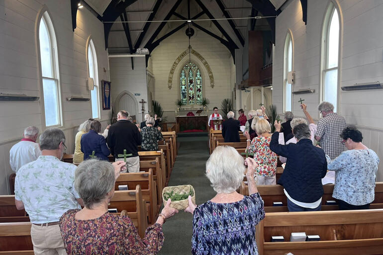 Members of Northern Wairoa parish in Dargaville raise their harakeke palm crosses for blessing, Palm Sunday 2026.