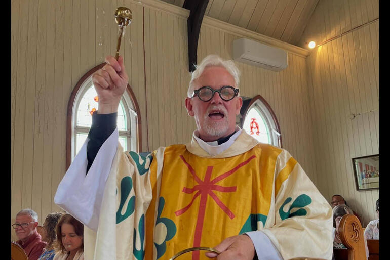 The Reverend Fred Brunell sprinkles the congregation with holy water during the renewal of baptismal vows at St Jude's Avondale this Easter.