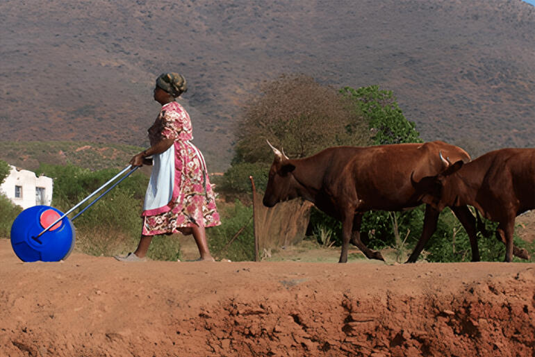 A woman uses a roller-drum water transporter which saves hours of walking and lifting for Amhara area villagers in Ethiopia through 'Bricks for Life.'
